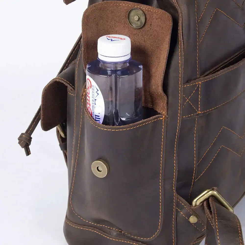 close-up of a brown leather bag with a bottle of water in its side pocket for maximum functionality.