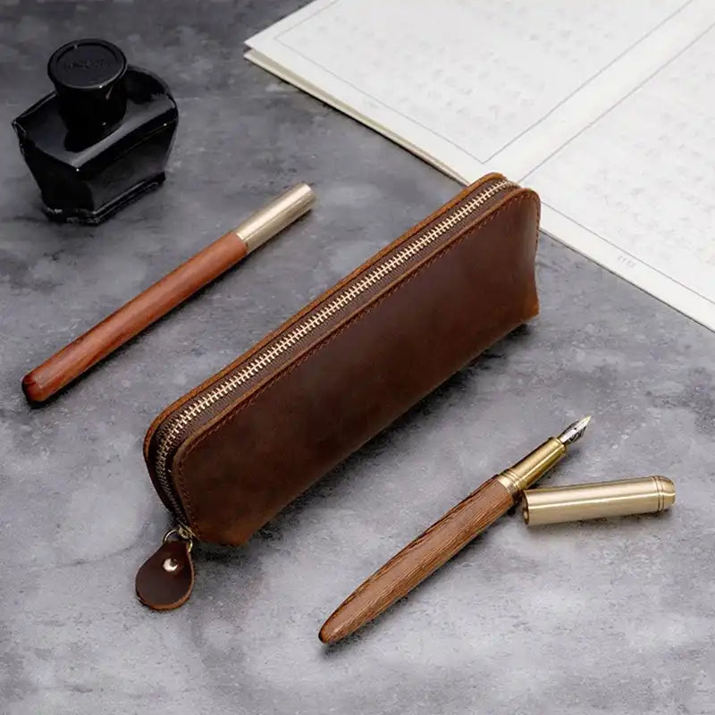 Stylish brown leather pencil case with zipper and writing tools