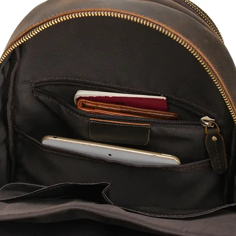 Interior image of a shoulder bag with several compartments for organization, containing a cell phone, wallets and other items. 