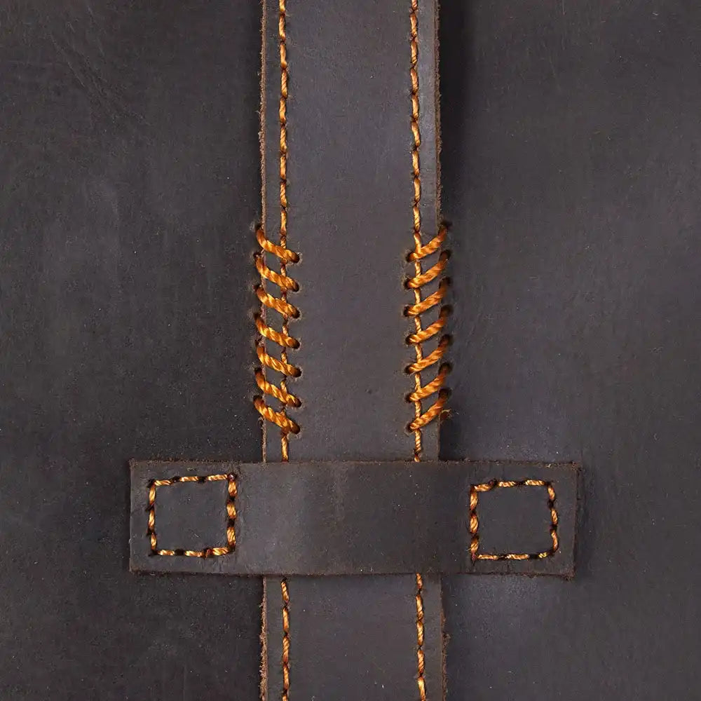 Close-up of dark brown leather bag stitching with orange thread.
