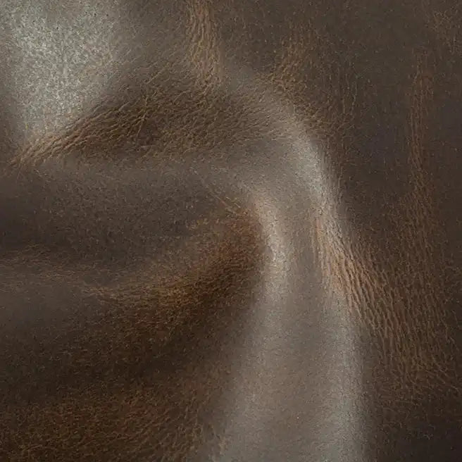 Dark brown leather surface showcasing natural grain and softness.
