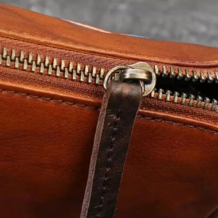 Detail of the zipper on a brown leather bag, highlighting the quality and finish of the product.