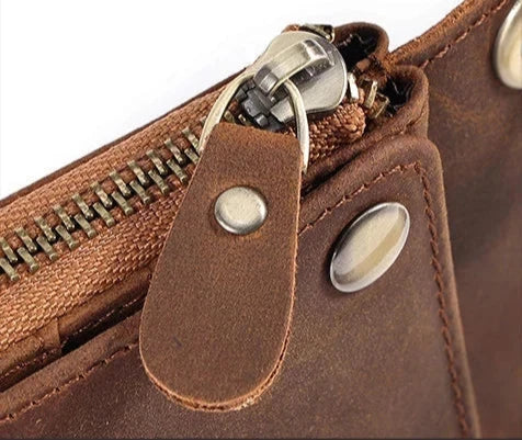 Detail of a zipper on a brown leather wallet, highlighting the quality of the material and the elegant design.