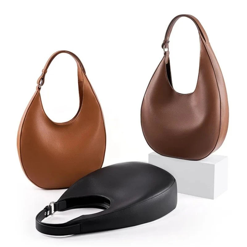Display of three elegant brown leather bags, with a moon design in coffee, brown and black colors, front view.