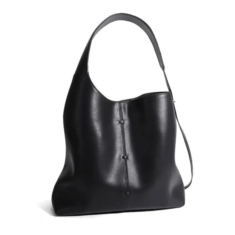 Elegant black leather bag with a modern design and adjustable strap, front view.