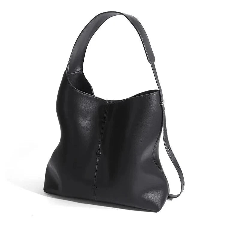 Elegant black leather bag with a modern design and adjustable strap, back view.