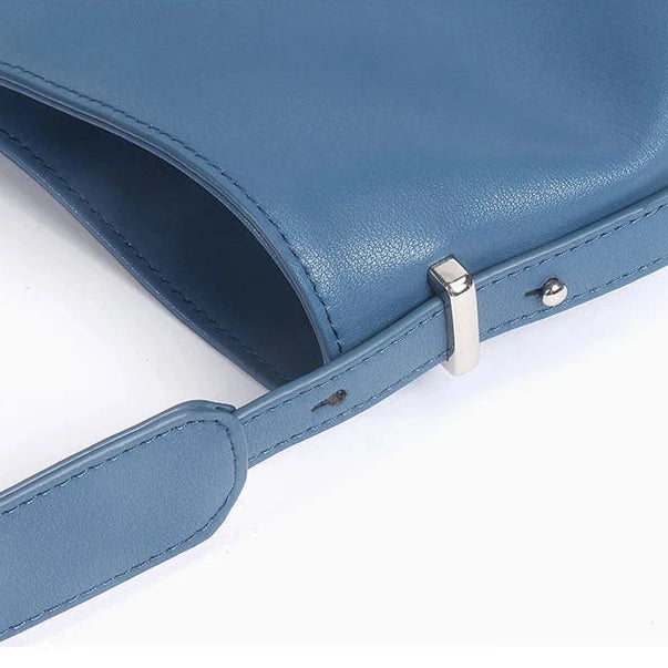 Blue leather bag with metal details of the adjustable strap.