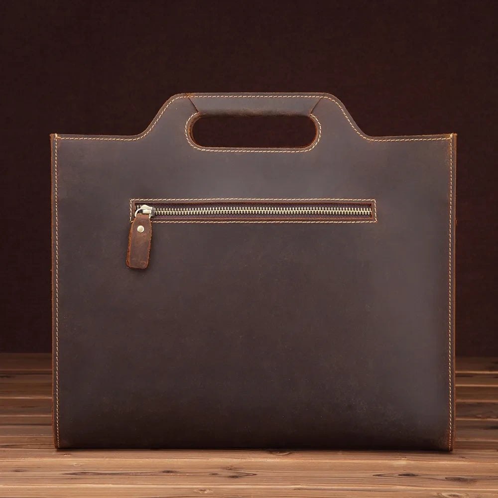An elegant brown leather zippered briefcase, with soft handle, perfect for carrying documents, back view.