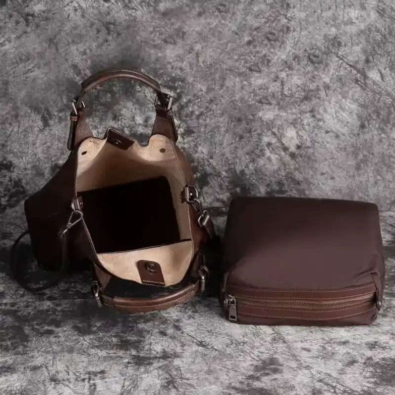 view of an open stylish brown handbag showing its interior and an additional pouch.