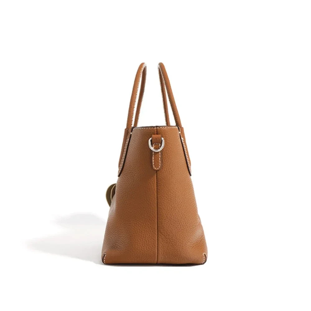 Elegant brown leather handbag with dual handles - side view.