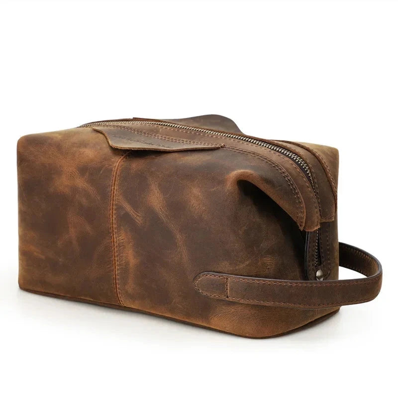 Brown leather toiletry bag with zipper closure and soft handle, ideal for storing personal items.