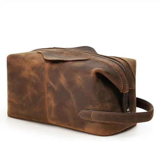 Brown leather toiletry bag with zipper closure and soft handle, ideal for storing personal items.