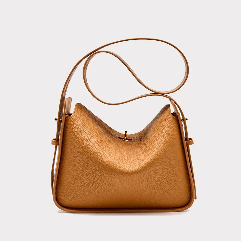 Brown leather bag with adjustable strap and modern, elegant design, front view.