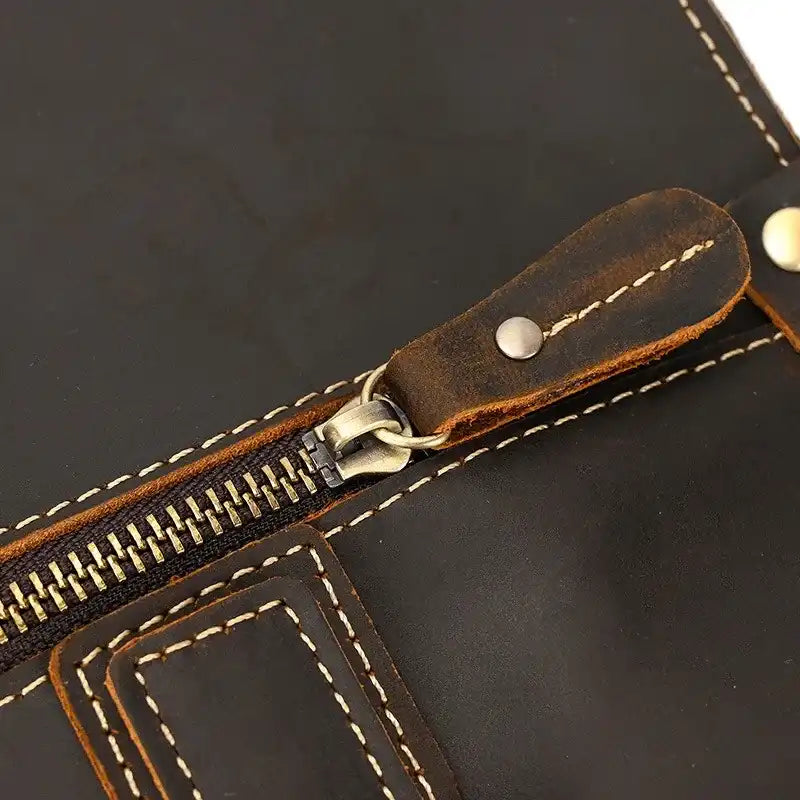 coffee brown leather bag with a zipper, highlighting the detail of the clasp and stitching. 