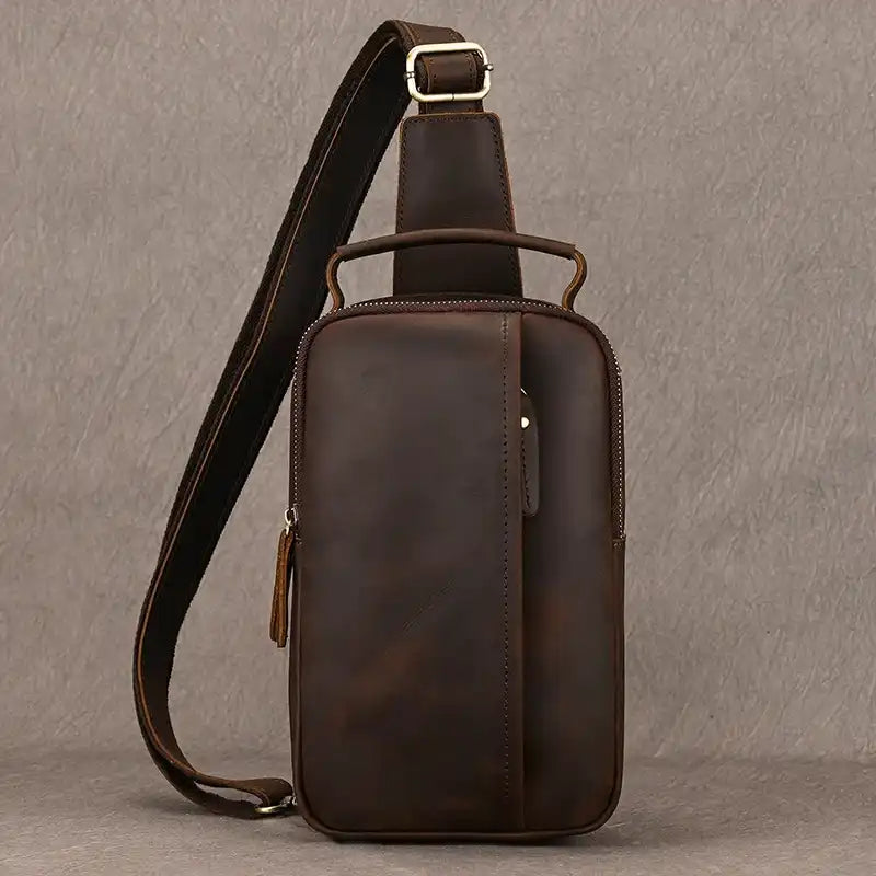 Dark brown leather crossbody bag with front pocket and adjustable strap, front view.