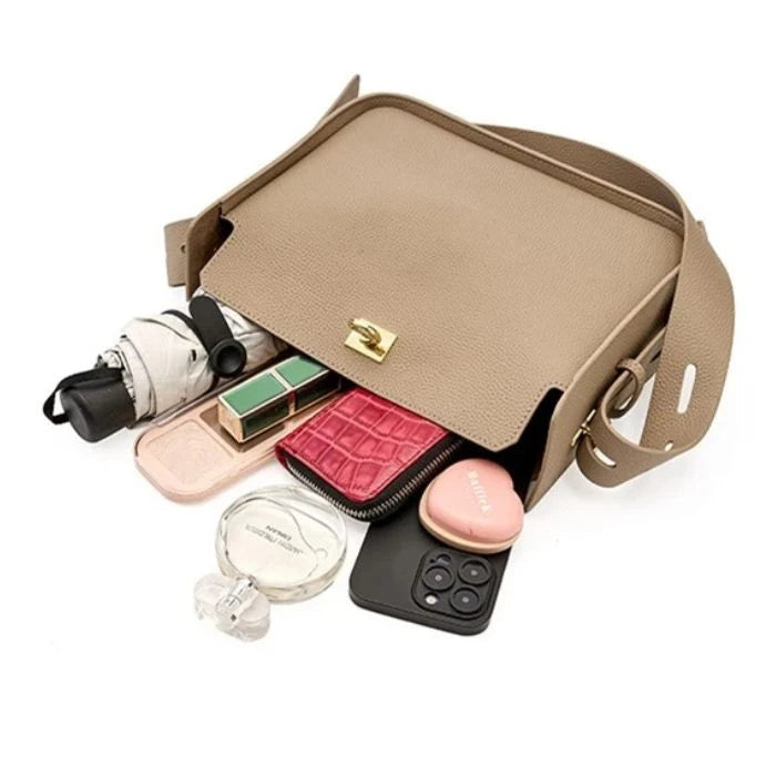 A stylish gray women's leather bag, with various items such as makeup, perfume, phone and an umbrella, perfect for everyday use.