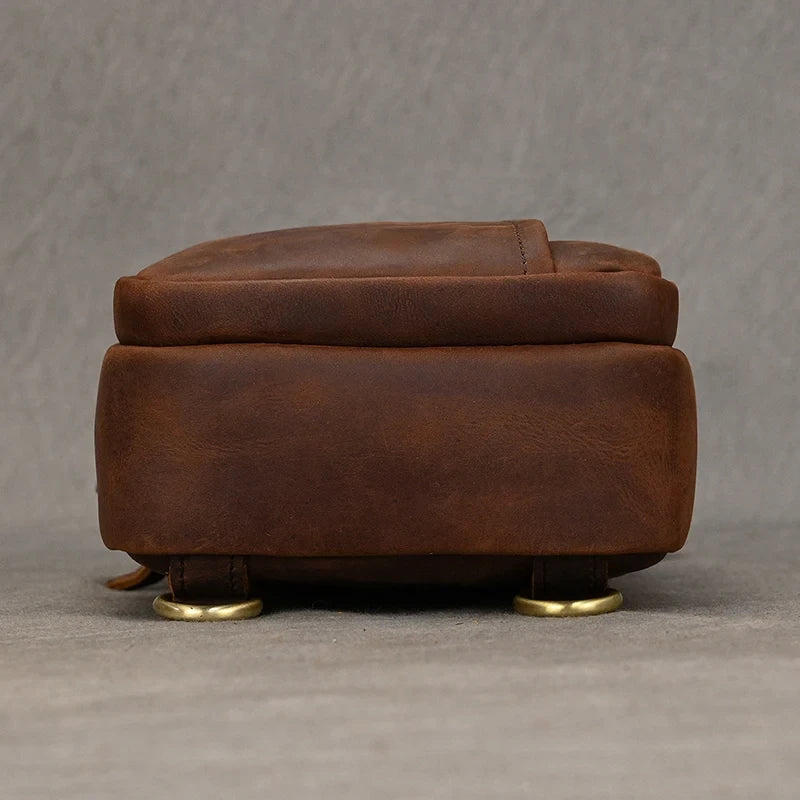 Bottom view of a red brown leather bag with metal details, highlighting the elegant design and texture of the material. 