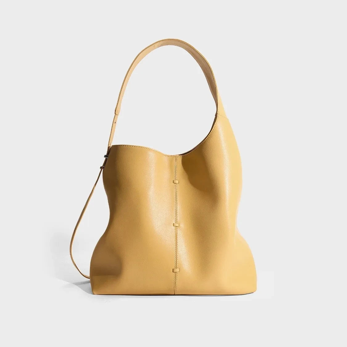 Elegant yellow leather bag with a modern design and adjustable strap, back view.