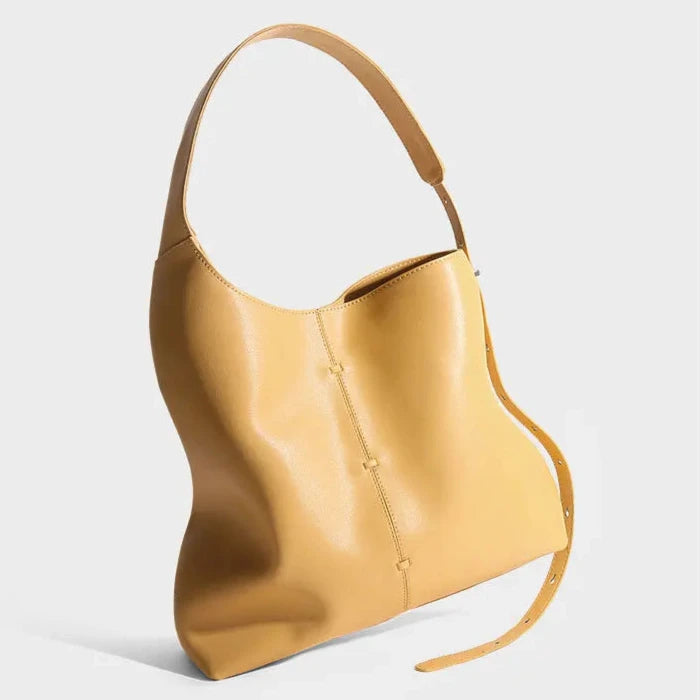 Elegant yellow leather bag with a modern design and adjustable strap.
