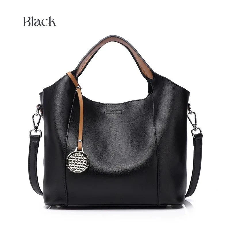 Black leather bag with soft detachable handles and elegant charm, front view.