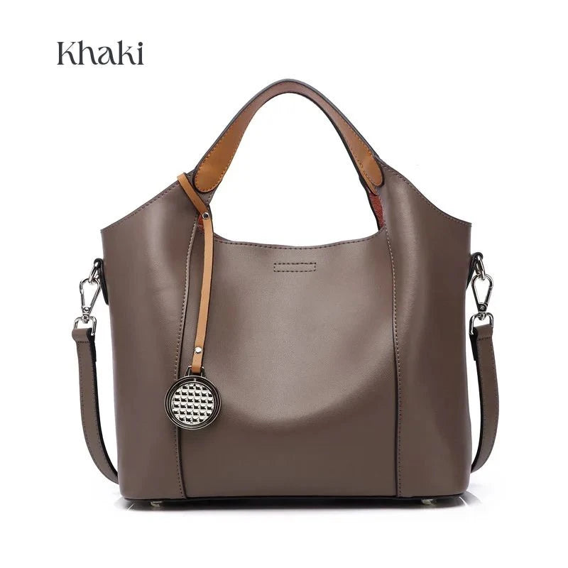 Khaki leather bag with soft detachable handles and elegant charm, front view.