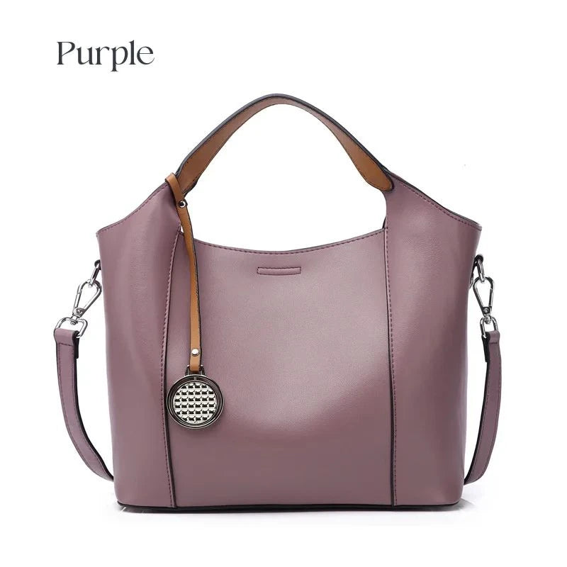 Purple leather bag with soft detachable handles and elegant charm, front view.