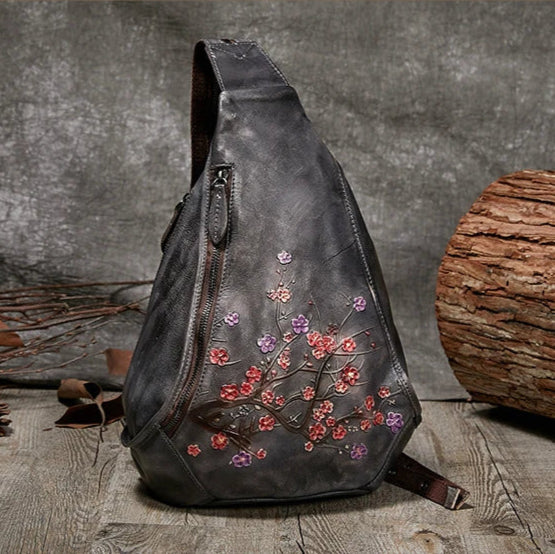 Stylish gray leather shoulder bag with floral embossed design - front view.