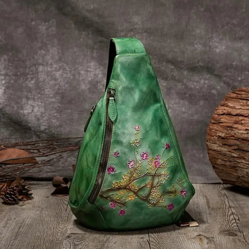 Stylish green leather shoulder bag with floral embossed design - front view.