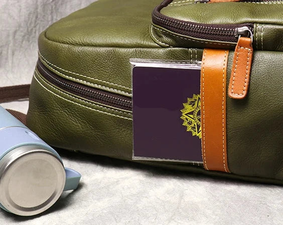 close-up view of a green leather backpack with a practical side pockets.