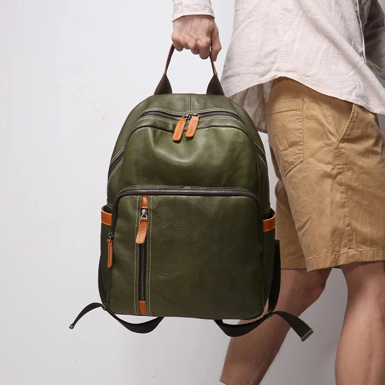 Green leather backpack held by handle by a man wearing white shirt and light brown shorts.