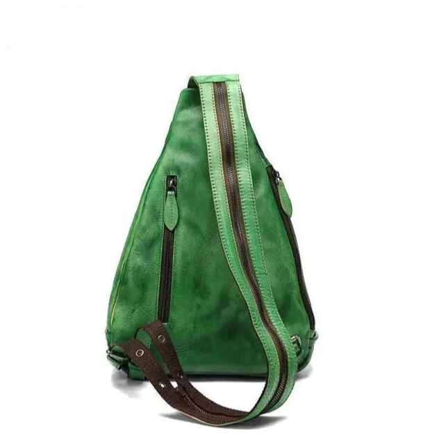 back view of a triangular shaped green leather shoulder bag with multiple zippers and a unique strap design.