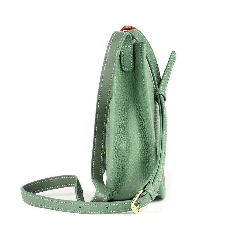 Side view of a stylish green leather crossbody bag with a long adjustable strap
