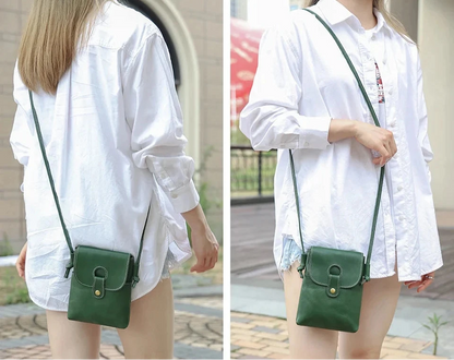 a woman wearing a loose white shirt  holding a green leather crossbody bag in outdoor setting.