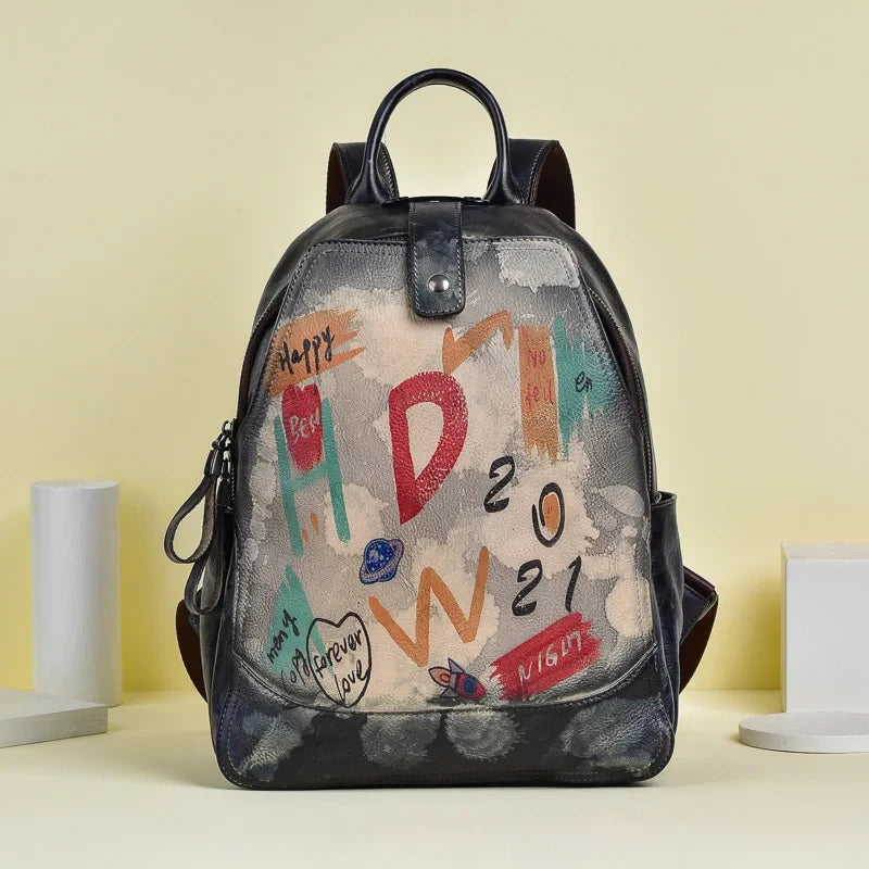 Grey leather backpack with an artistic design filled with vibrant colors and drawings, front view.