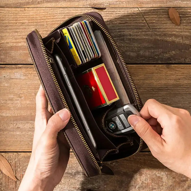 An organized brown leather wallet containing various cards, a phone and car keys.