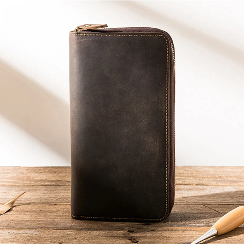 An elegant zippered wallet made of brown leather with visible stitching details.