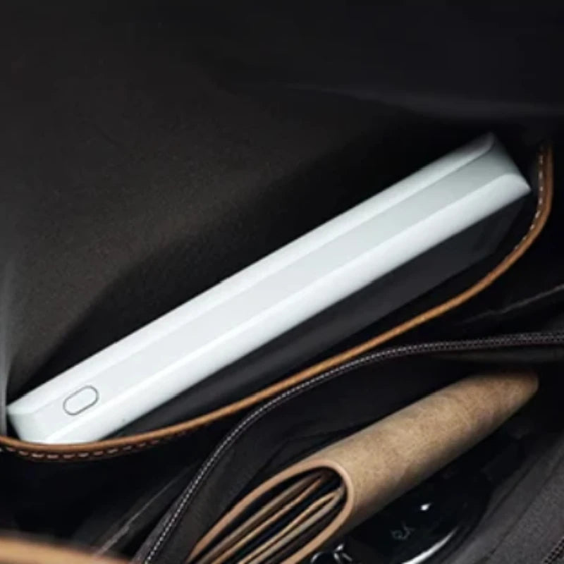 close-up view of a bag showing an electronic device in a compartment. Ideal for organizing accessories.