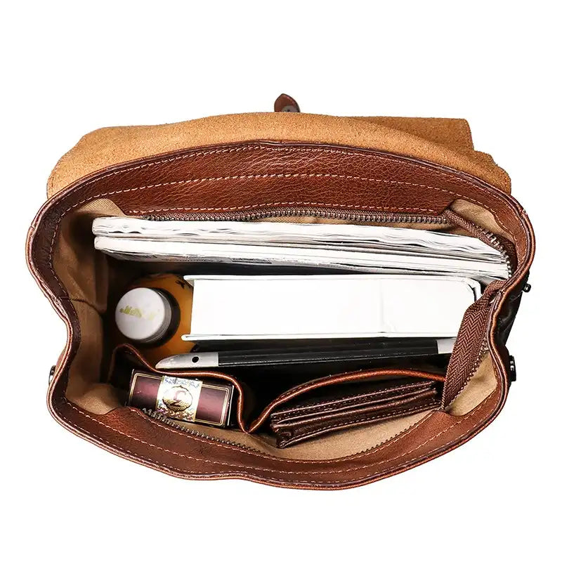 A top view of a leather handbag showing its spacious interior filled with daily essentials.