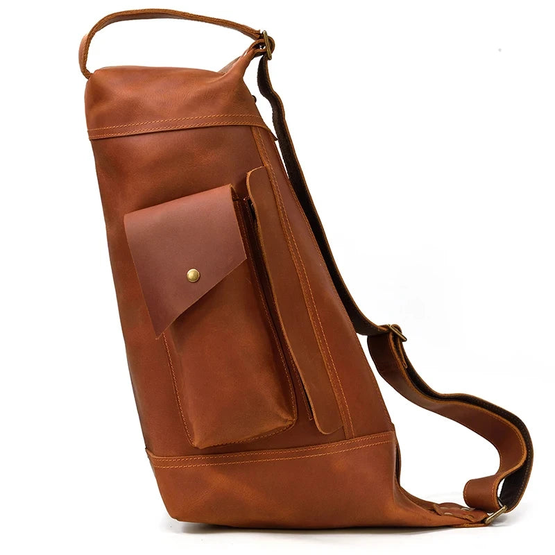 Side view of a large light brown vintage leather bag with a pocket and zipper.