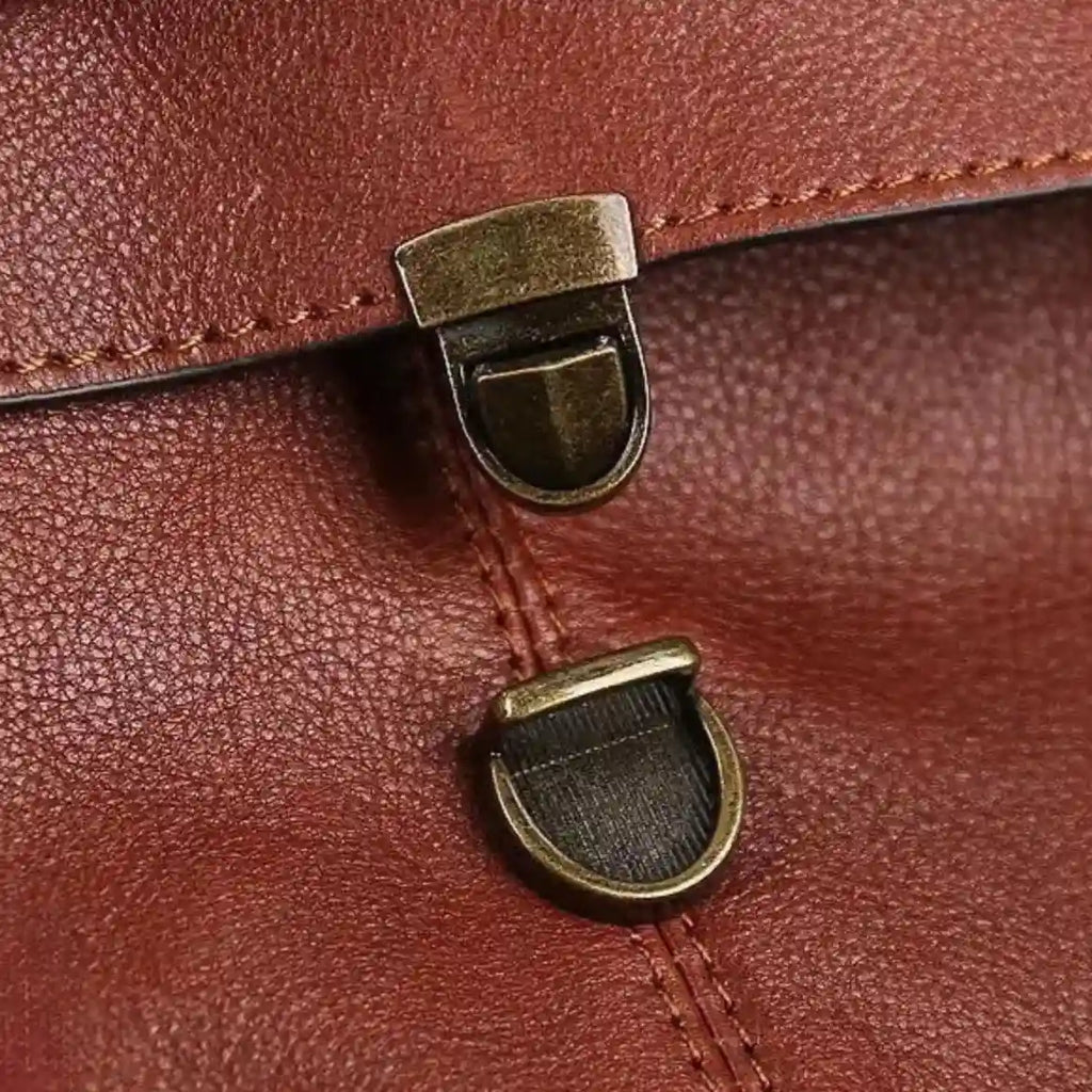 Detail of clasps on a leather material, highlighting the texture and metal finishes.