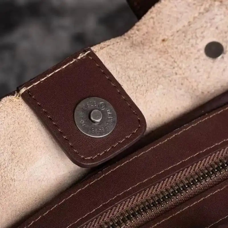 Detail of a brown leather and metal clasp on a high-quality bag.
