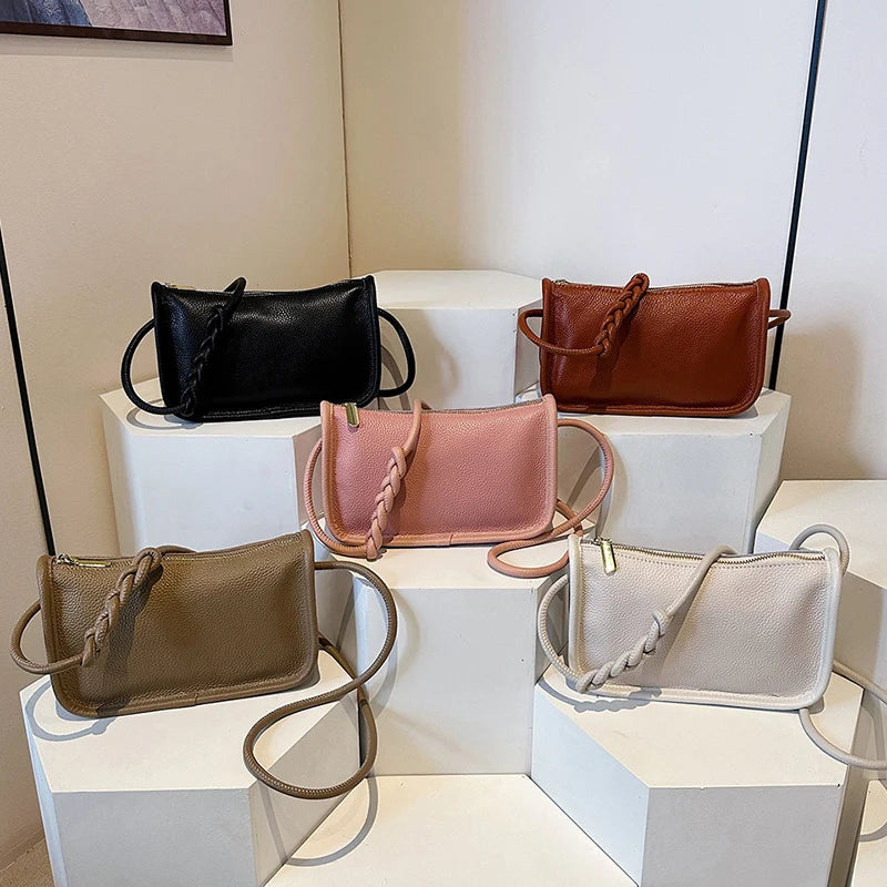 Chic leather bags displayed elegantly on pedestals, highlighting their unique braided straps and various colors.
