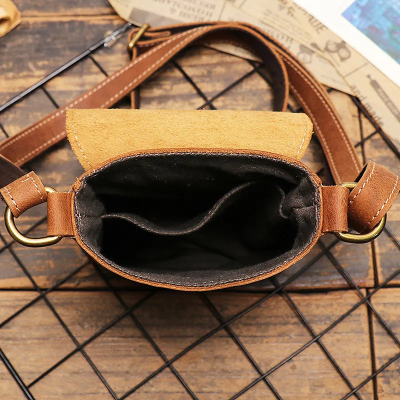 Inside view of a stylish leather mini shoulder bag with brown exterior and leather strap.