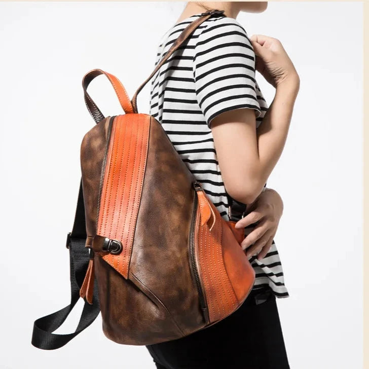 Modern patchwork backpack in orange & brown worn by a woman, showcasing a chic design.