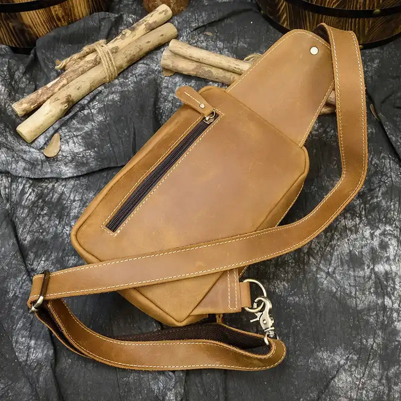 Brown leather bag with a classic design and a long handle and back zipped pocket, top view.