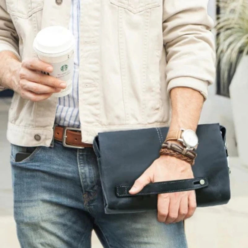 Man in a light jacket holding a blue leather clutch.