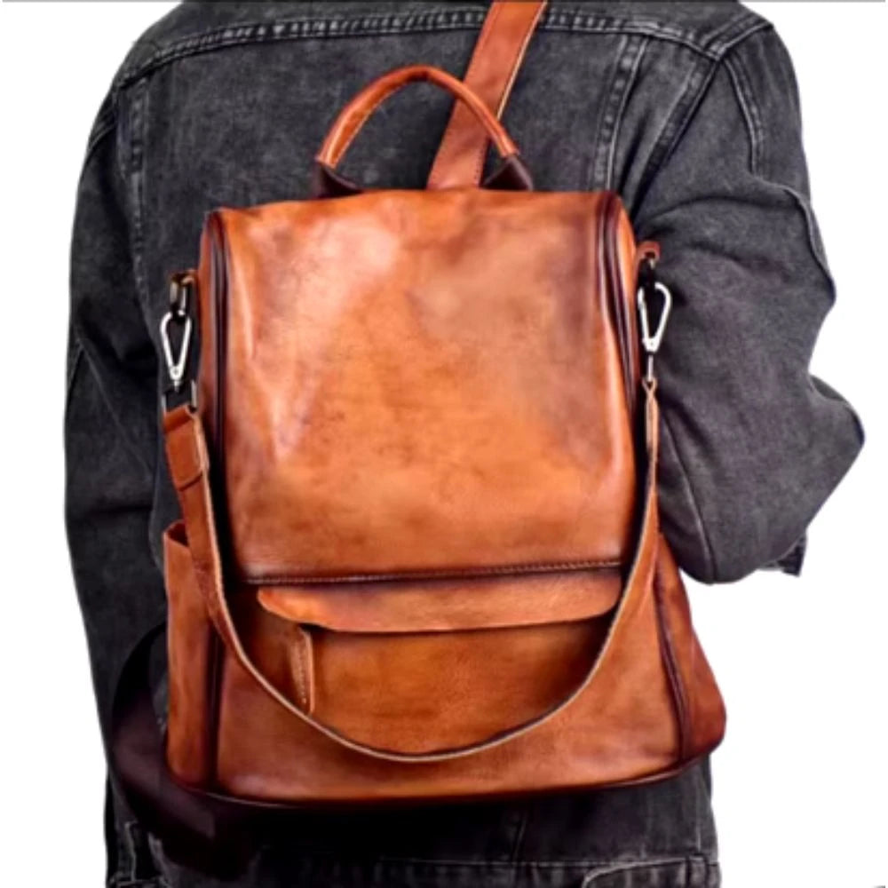 Stylish anti-theft brown leather backpack worn on a person's back.
