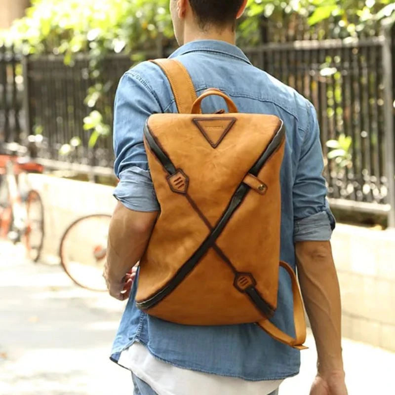 Man wearing a stylish brown vintage  leather backpack with unique design, on back.