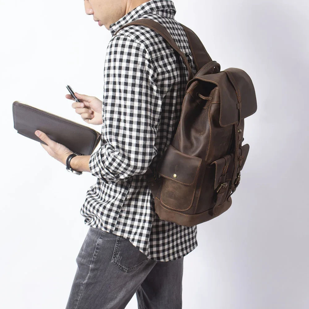 Man wearing a checkered shirt with a brown leather backpack on his back, showcasing elegance and style.