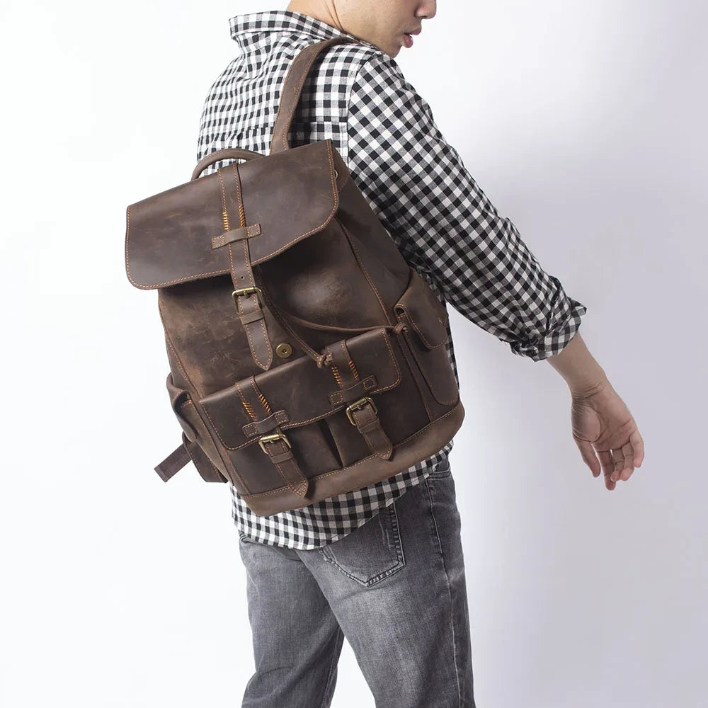 A man wearing a brown leather backpack, highlighting stylish details and practicality in fashion.